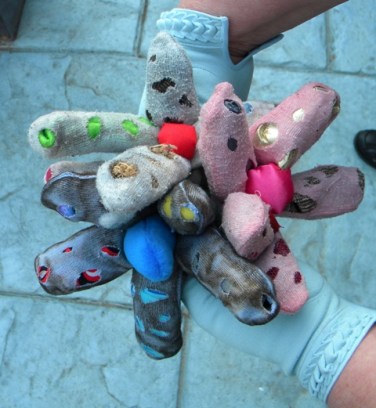 Image of gloved hands holding stuffed dyed gloves